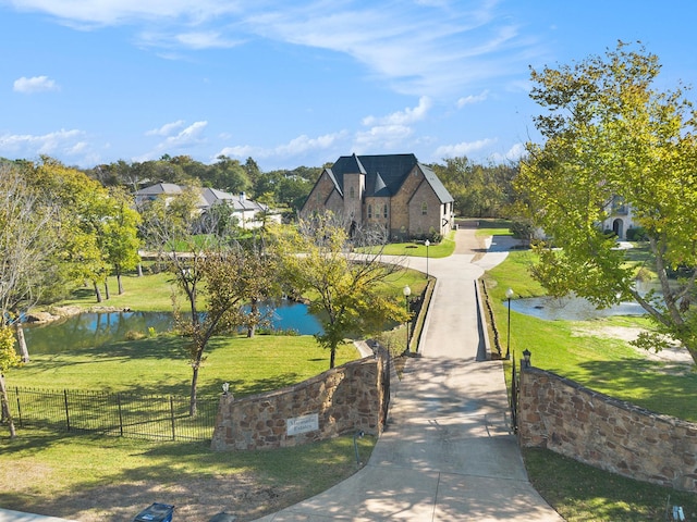 view of home's community featuring a water view and a lawn