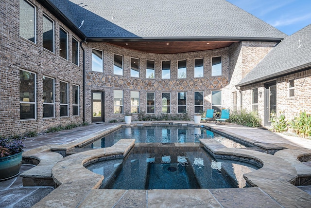 view of pool with an in ground hot tub and a patio