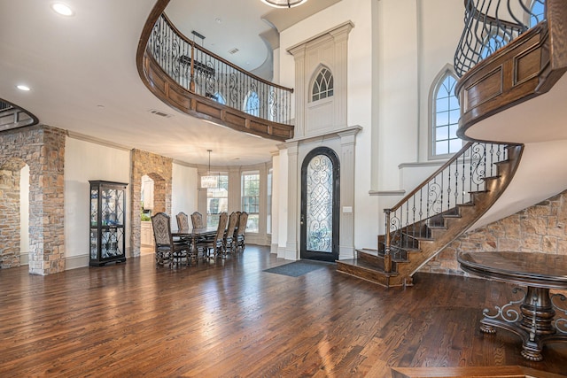 entryway featuring a towering ceiling and dark hardwood / wood-style floors