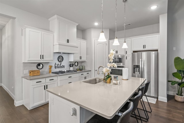 kitchen with white cabinetry, sink, stainless steel appliances, a center island with sink, and custom exhaust hood