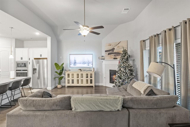 living room featuring dark hardwood / wood-style flooring, ceiling fan, and lofted ceiling