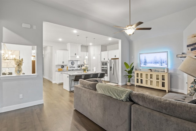 living room featuring hardwood / wood-style flooring, ceiling fan, and lofted ceiling