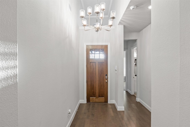 entrance foyer featuring dark wood-type flooring and an inviting chandelier