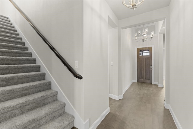 foyer entrance with a notable chandelier and wood-type flooring