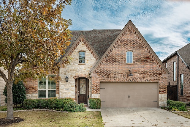 english style home featuring a front lawn and a garage