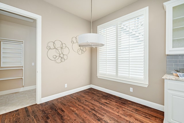 unfurnished dining area featuring dark hardwood / wood-style flooring