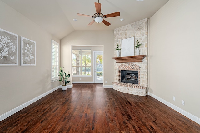 unfurnished living room with ceiling fan, lofted ceiling, dark wood-type flooring, and a brick fireplace