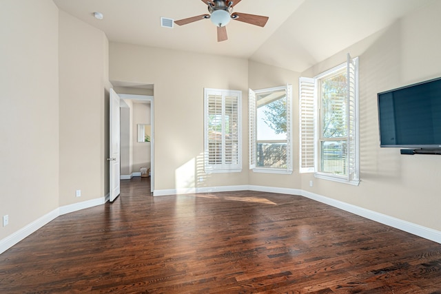 empty room featuring lofted ceiling, a wealth of natural light, ceiling fan, and dark hardwood / wood-style floors