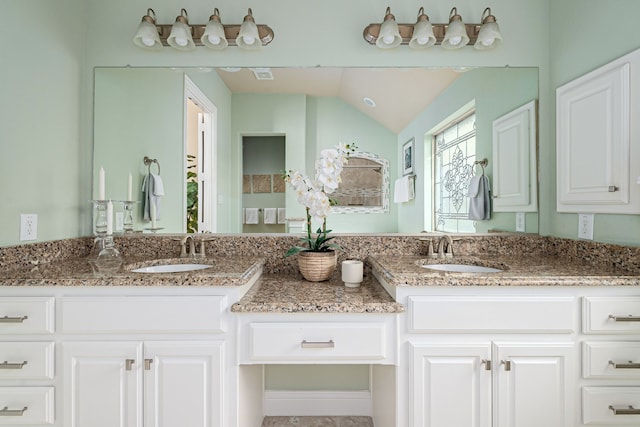 bathroom with vanity and lofted ceiling