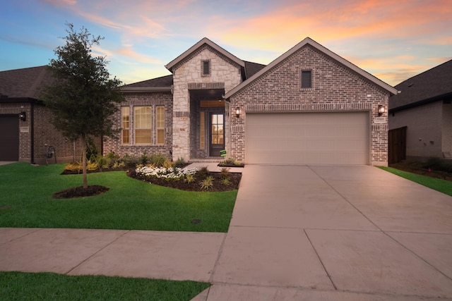 view of front of property with a garage and a lawn