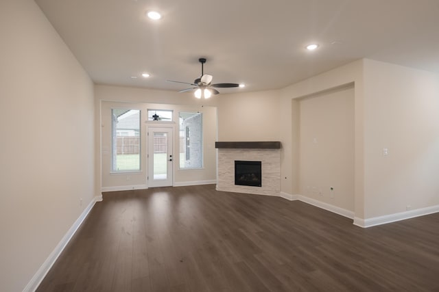 unfurnished living room featuring ceiling fan and dark wood-type flooring