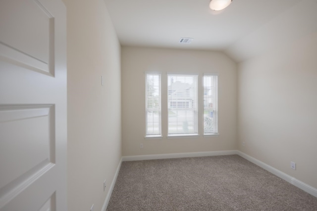 spare room featuring carpet floors and lofted ceiling