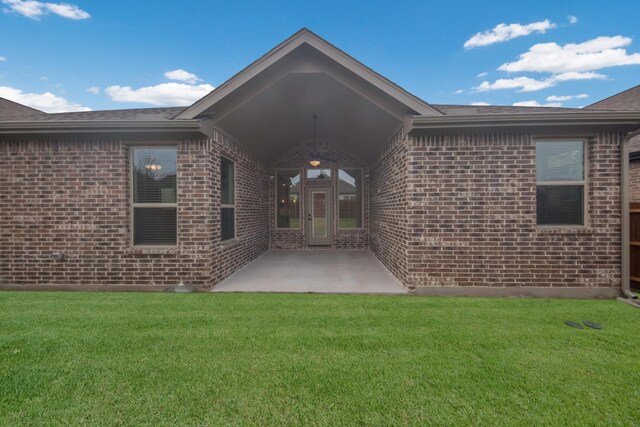 back of house featuring a lawn and a patio area