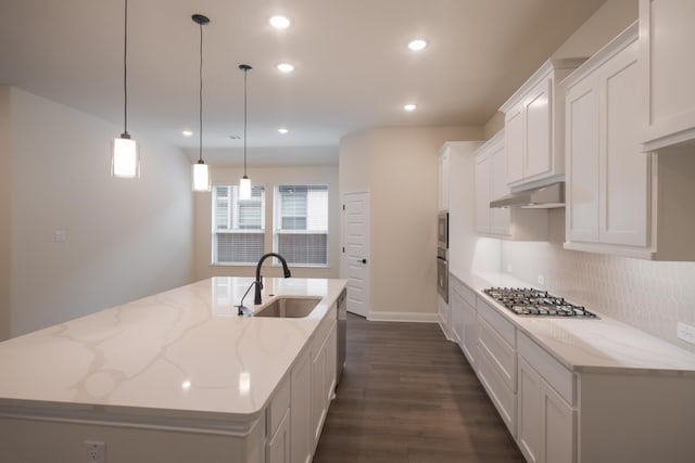 kitchen featuring sink, decorative light fixtures, a kitchen island with sink, white cabinets, and appliances with stainless steel finishes