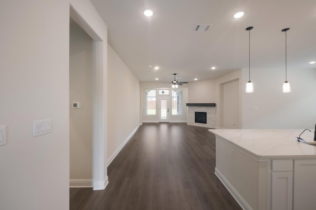 unfurnished living room with ceiling fan and dark wood-type flooring