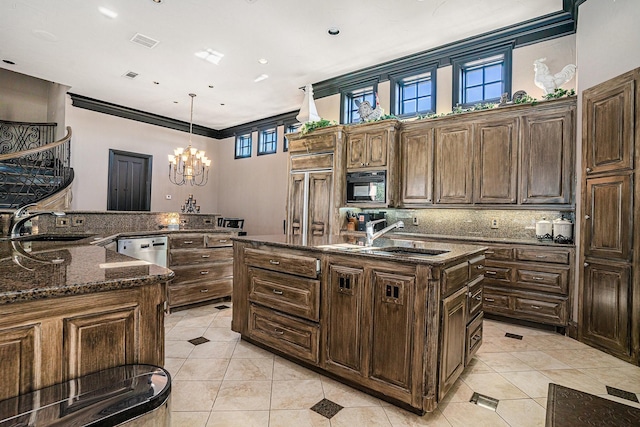 kitchen with sink, decorative light fixtures, a kitchen island with sink, and dishwasher