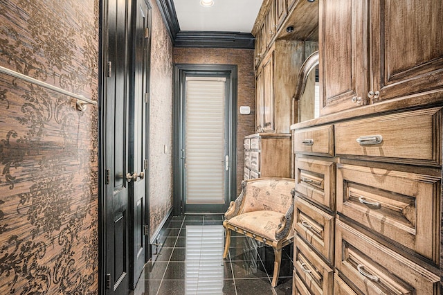 interior space featuring dark tile patterned flooring and crown molding