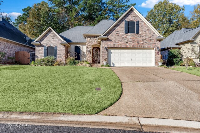 view of property with a garage and a front lawn