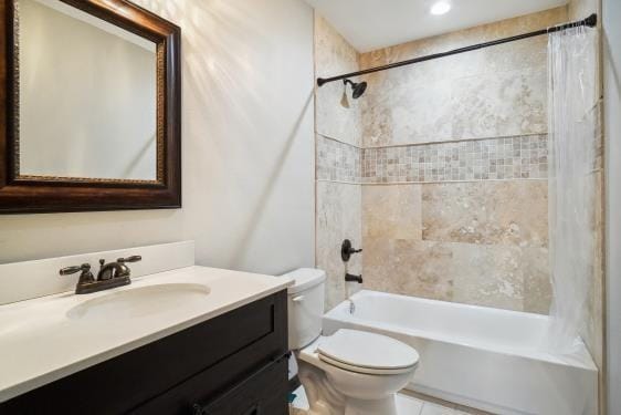 full bathroom with tiled shower / bath combo, toilet, and vanity