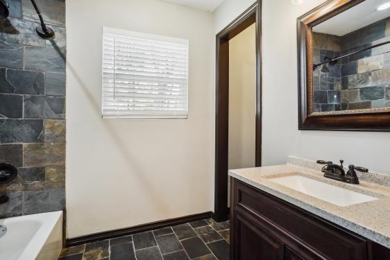 bathroom featuring tiled shower / bath combo and vanity