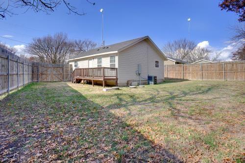 rear view of house featuring a deck, central AC unit, and a lawn