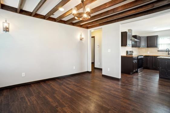 unfurnished living room with beamed ceiling, dark hardwood / wood-style flooring, sink, and a chandelier