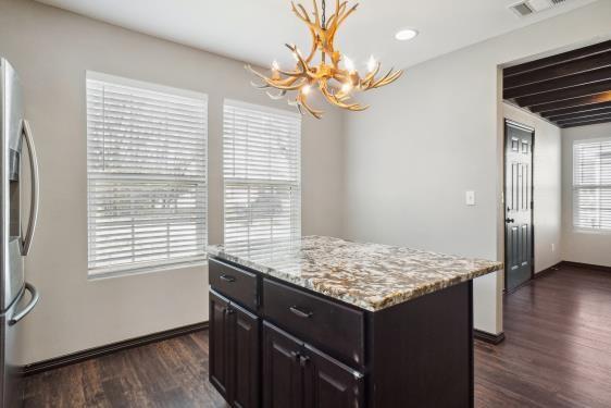 kitchen with stainless steel fridge with ice dispenser, decorative light fixtures, a center island, and a healthy amount of sunlight