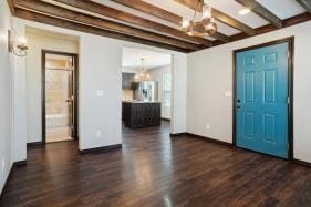 foyer entrance with beamed ceiling, dark hardwood / wood-style floors, and a notable chandelier