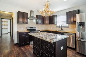 kitchen with a kitchen island, dark hardwood / wood-style floors, ventilation hood, sink, and stainless steel appliances