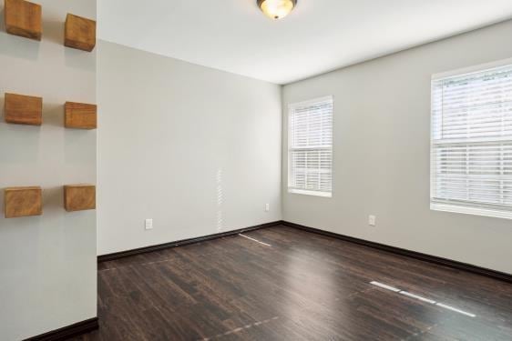 spare room with dark wood-type flooring