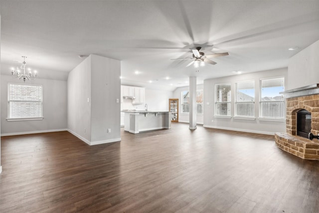 unfurnished living room with dark hardwood / wood-style floors, lofted ceiling, and a fireplace