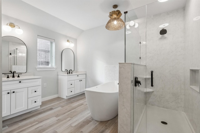 bathroom with a sink, a freestanding bath, walk in shower, and wood finished floors