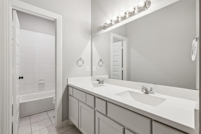 bathroom featuring tile patterned flooring, double vanity, toilet, and a sink