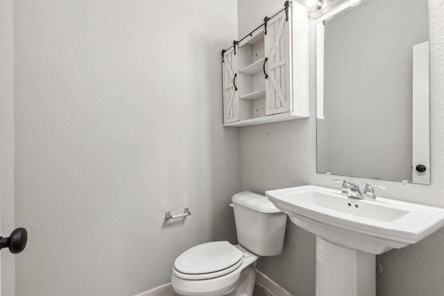 half bath with toilet and baseboards