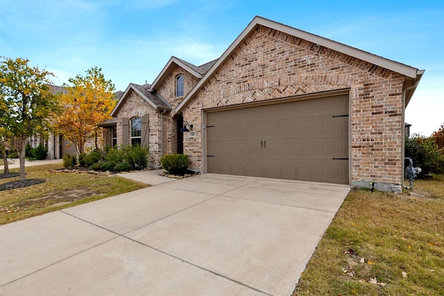 view of front of property with an attached garage, brick siding, and driveway