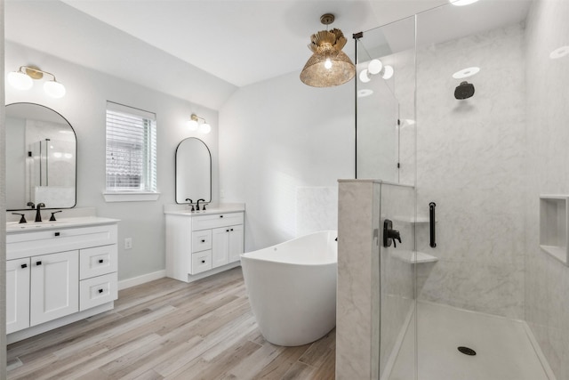 bathroom featuring shower with separate bathtub, vanity, lofted ceiling, and wood-type flooring