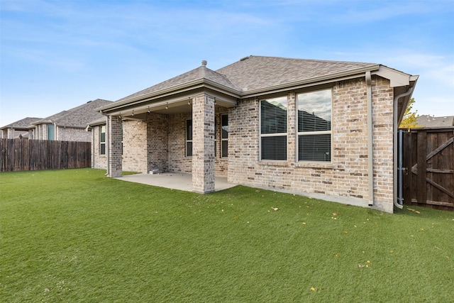 rear view of property with a lawn and a patio