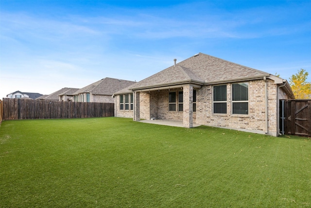 rear view of property with a yard and a patio