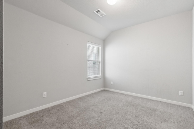 carpeted spare room featuring lofted ceiling