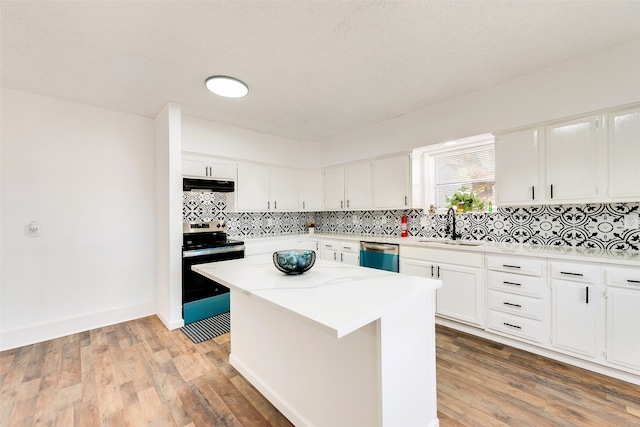 kitchen with a kitchen island, appliances with stainless steel finishes, sink, and white cabinets