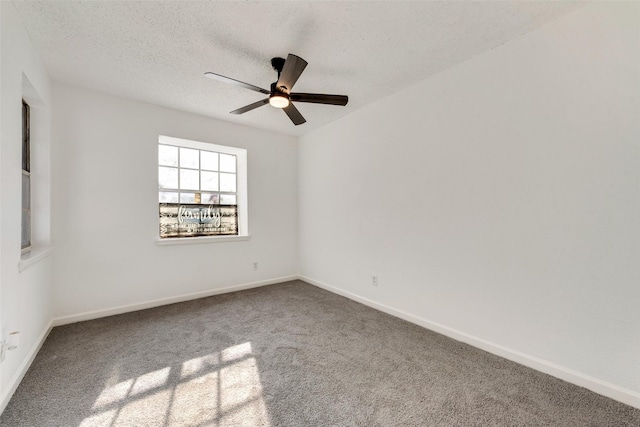 carpeted spare room featuring ceiling fan and a textured ceiling