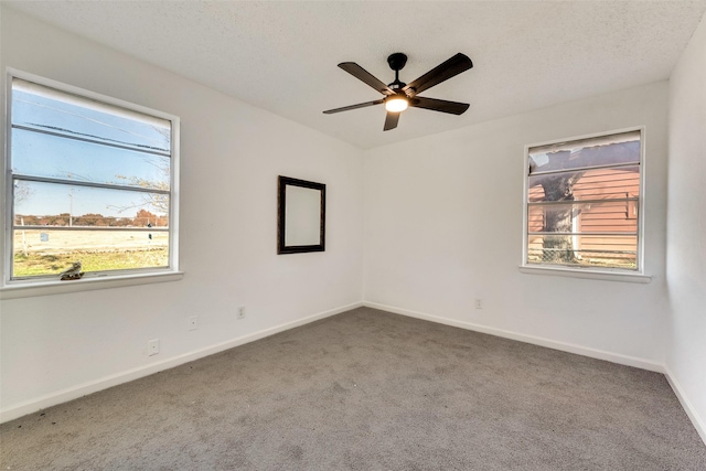 unfurnished room with a wealth of natural light, carpet floors, and ceiling fan