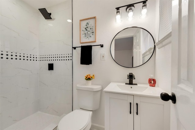 bathroom with vanity, toilet, and a tile shower