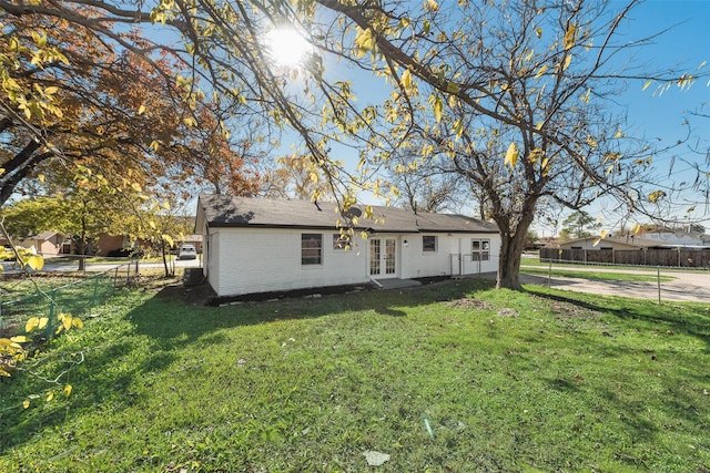 back of property with a yard and french doors