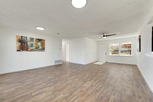 unfurnished living room featuring hardwood / wood-style flooring, a textured ceiling, and ceiling fan