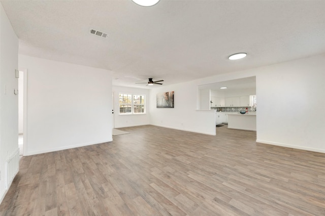 unfurnished living room featuring ceiling fan and light hardwood / wood-style floors