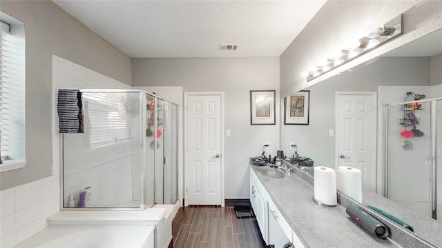 bathroom featuring vanity, shower with separate bathtub, and a textured ceiling