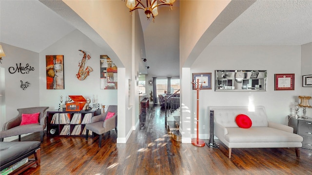 interior space featuring lofted ceiling, a chandelier, dark wood-type flooring, and a textured ceiling