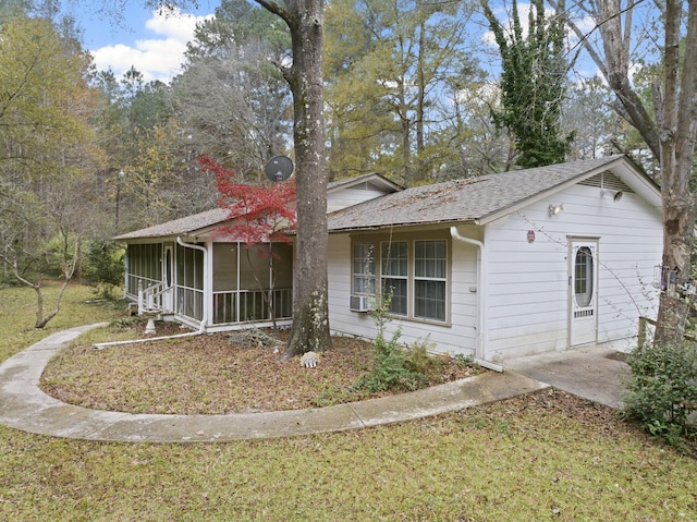 ranch-style house featuring a front lawn and a sunroom