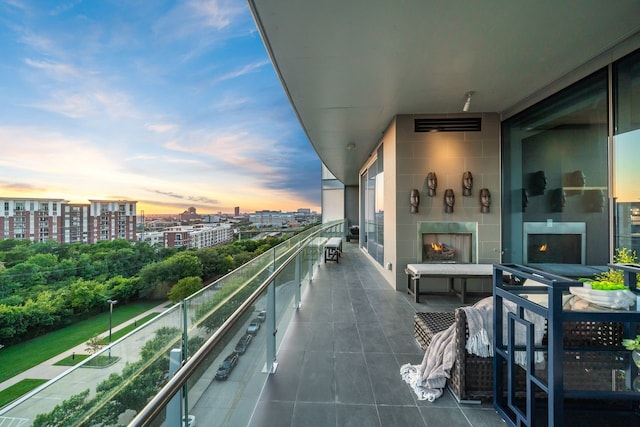 balcony at dusk featuring a tile fireplace